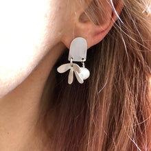 Load image into Gallery viewer, Door and Flower Sterling Silver Post Earrings with White Pearl on ear glowing catching the light 

